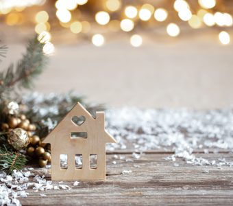 Winter cozy background with festive decor details, snow on a wooden table and bokeh. The concept of a festive atmosphere at home.